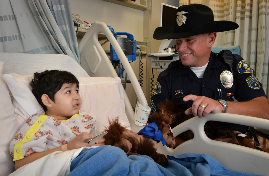 Elishah Maldonado, 4, talks to Sgt. Rodney Duckwitz from his hospital bed at CHOC during a visit by the Anaheim PD. Photo by Steven Georges/Behind the Badge OC