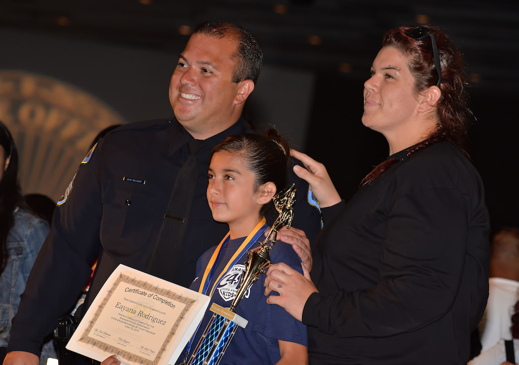 Sgt. Jake Gallacher with 11-year-old Eayana Rodriguez and her mother Ukia Anderson at Anaheim PD’s Jr. Cadet Graduation Ceremony. Photo by Steven Georges/Behind the Badge OC