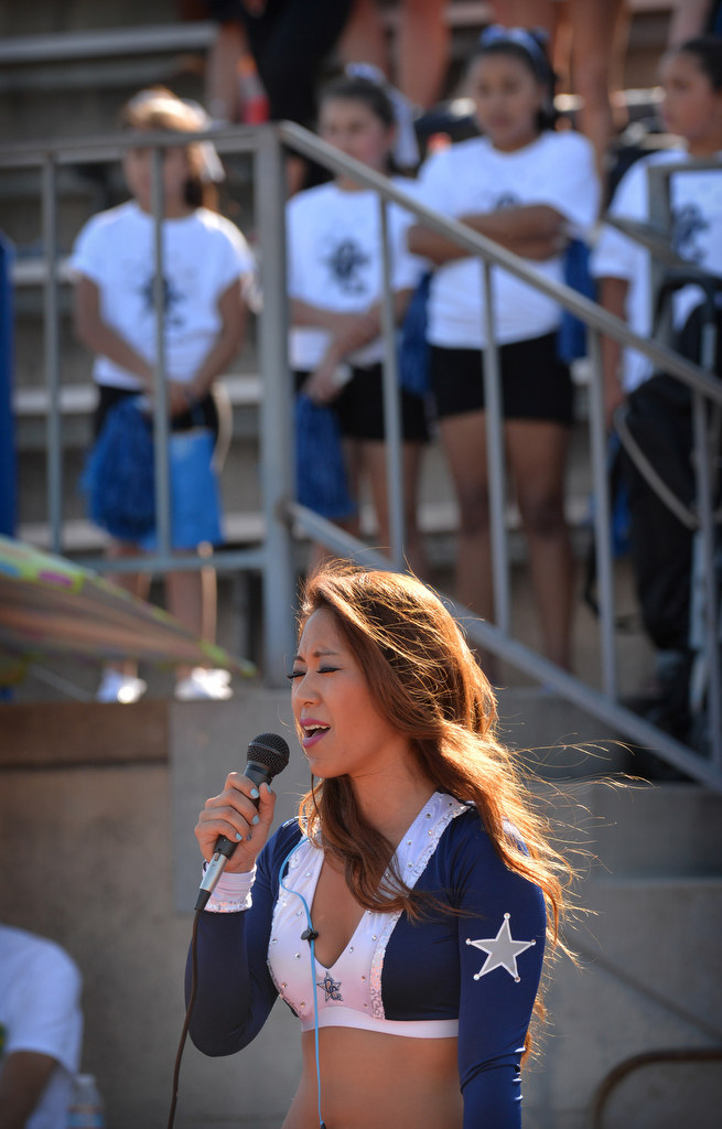 Flora Yang, an OC Lawgirl, sings the national anthem with the Jr. Lawgirls standing behind her at the start of the Orange County Lawmen national championship football game at Irvine High. Photo by Steven Georges/Behind the Badge OC