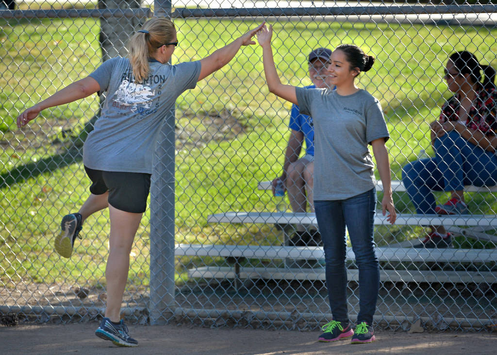Detective Carin Wright, left, gives Cadet Denise Bueno a high-five during the P2: Picnic with the Police kickball game at Ted Craig Regional Park in Fullerton. Photo by Steven Georges/Behind the Badge OC