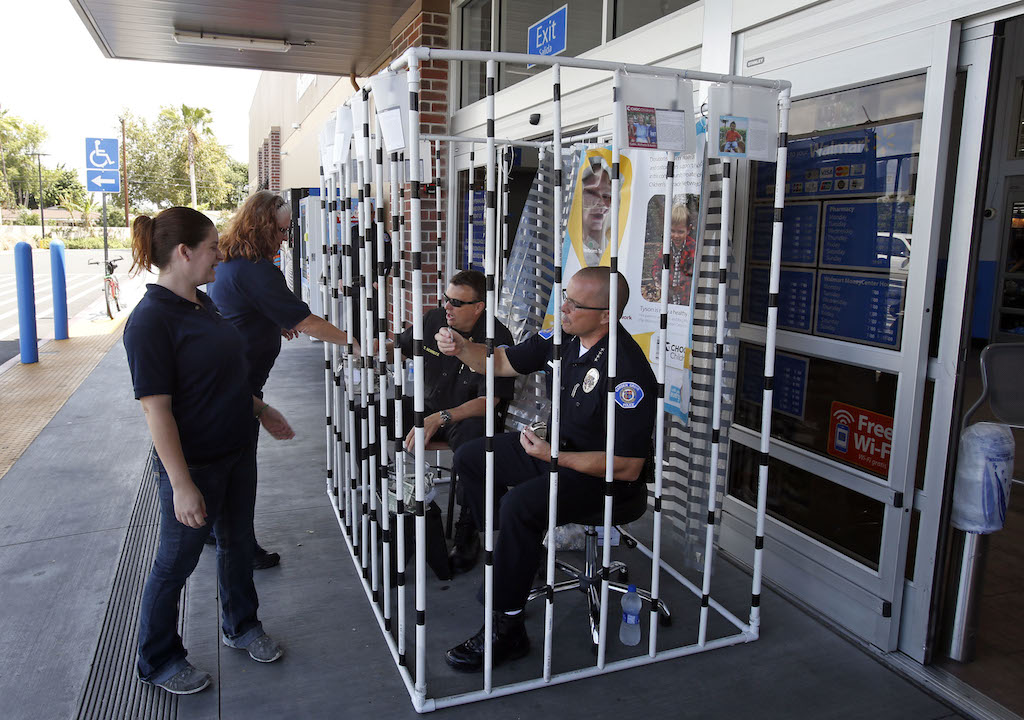 Walmart employees and shoppers donate money in support of a fundraiser for CHOC-Children’s Hospital of Orange County on June 5,  at Walmart in Garden Grove. Garden Grove Fire Chief Tom Schultz, left and Garden Grove Police Chief Todd Elgin solicited donation from their homemade jail cell in front of the Walmart in Garden Grove.  Photo by Christine Cotter/Behind the Badge OC