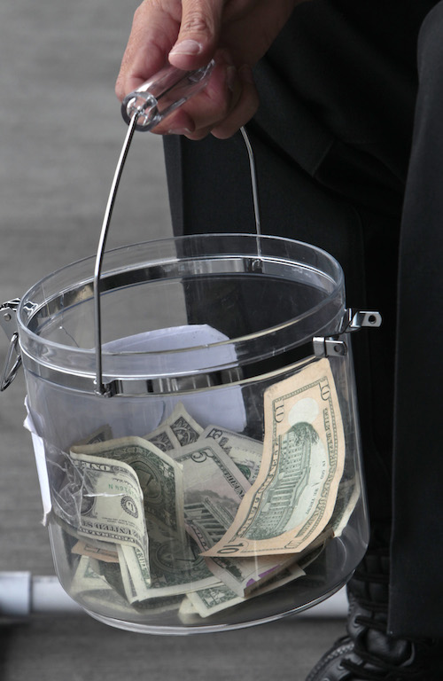 Walmart shoppers fill a bucket with cash in support of a fundraiser for CHOC-Children’s Hospital of Orange County on June 5,  at Walmart in Garden Grove. Garden Grove Fire Chief Tom Schultz and Garden Grove Police Chief Todd Elgin were locked in a homemade jail to collect donations with the proceeds directly going to CHOC. Photo by Christine Cotter/Behind the Badge OC