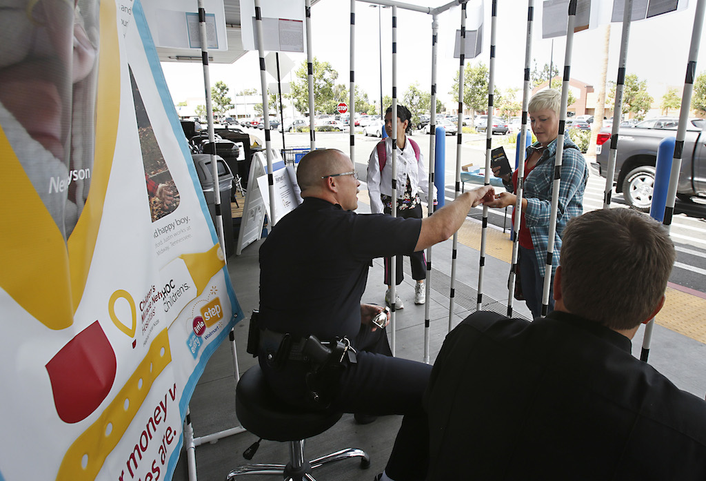 Walmart shoppers donate money in support of a fundraiser for CHOC-Children’s Hospital of Orange County on June 5, at the Walmart in Garden Grove. Garden Grove Fire Chief Tom Schultz and Garden Grove Police Chief Todd Elgin were locked in a homemade jail to collect the donations with the proceeds directly going to CHOC. Photo by Christine Cotter/Behind the Badge OC