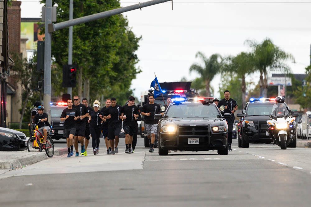 A patrol car leads Westminster police and Special Olympics athletes in  carrying the Flame of Hope. Photo by Jim Banks/Behind the Badge OC. 