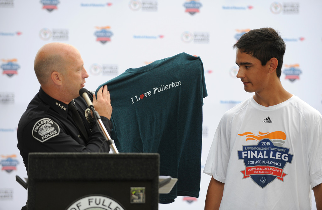 Fullerton Police Chief Dan Hughes, left, presents a "I Love Fullerton" t-shirt to Special Olympics athlete Brett Laza during the final leg of the Special Olympics torch run in front of Fullerton Police Department headquarters in Fullerton, Calif., on Monday, July 20, 2015. Photo by Carlos Delgado / Behind the Badge OC