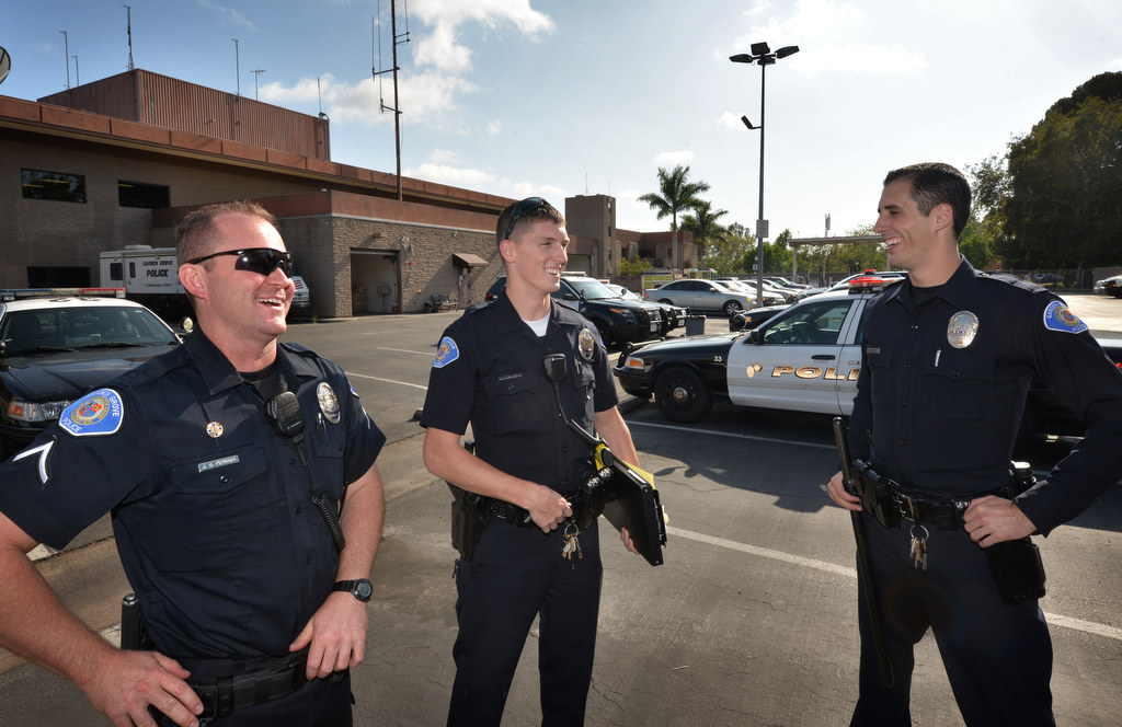 Garden Grove PD Officer Austin Laverty, right, talks about the days experiences with Officer Jason Perkins, left, and John Yergler, another new officer, as they arrive back at the station. Photo by Steven Georges/Behind the Badge OC