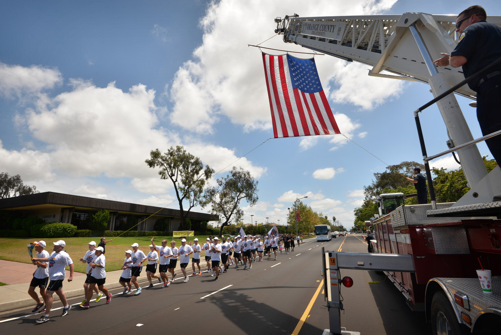 Runners from the Law Enforcement Torch Run Final Leg for Special Olympics pass Orange County Fire Authority Truck 17 as they arrive at the Cypress Civic Center for a ceremony. Photo by Steven Georges/Behind the Badge OC
