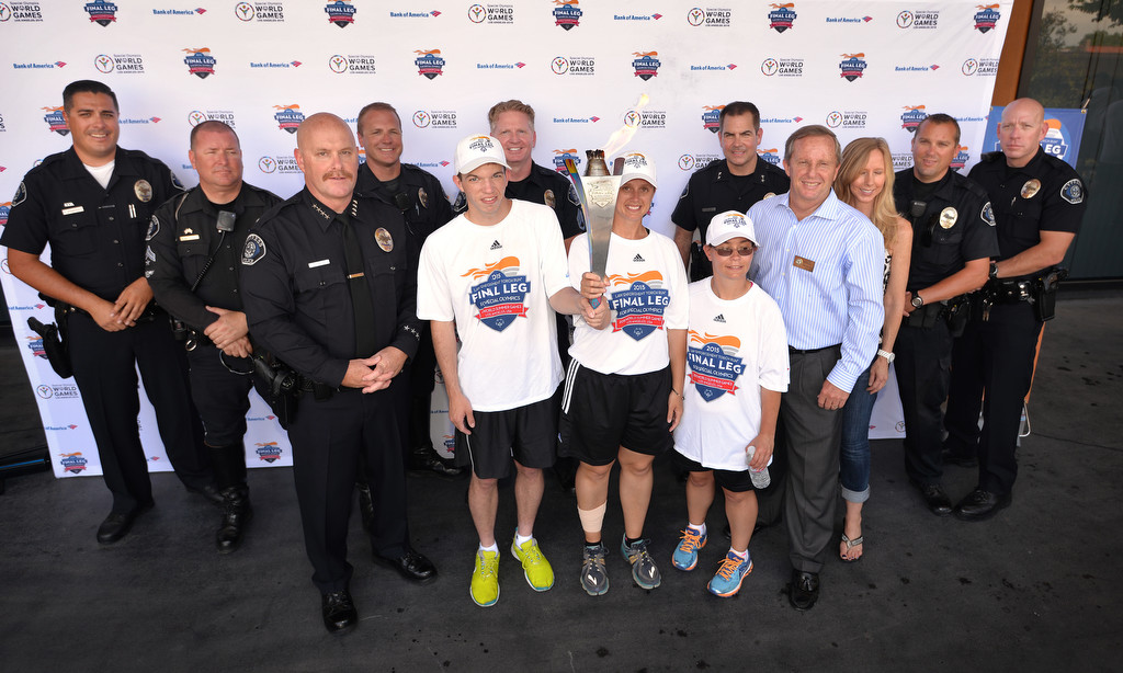Torch runners from the Law Enforcement Torch Run Final Leg for Special Olympics gather with the Cypress Police Department, including Chief Rod Cox and Cypress Mayor Rob Johnson, front row, left and right respectively, curing a ceremony at the Cypress Civic Center. Photo by Steven Georges/Behind the Badge OC