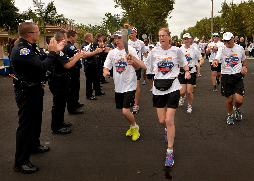 The Garden Grove Police Department, including Chief Todd Elgin, left, welcomes runners from the Law Enforcement Torch Run Final Leg for Special Olympics as they arrive at Garden Grove PD. Photo by Steven Georges/Behind the Badge OC