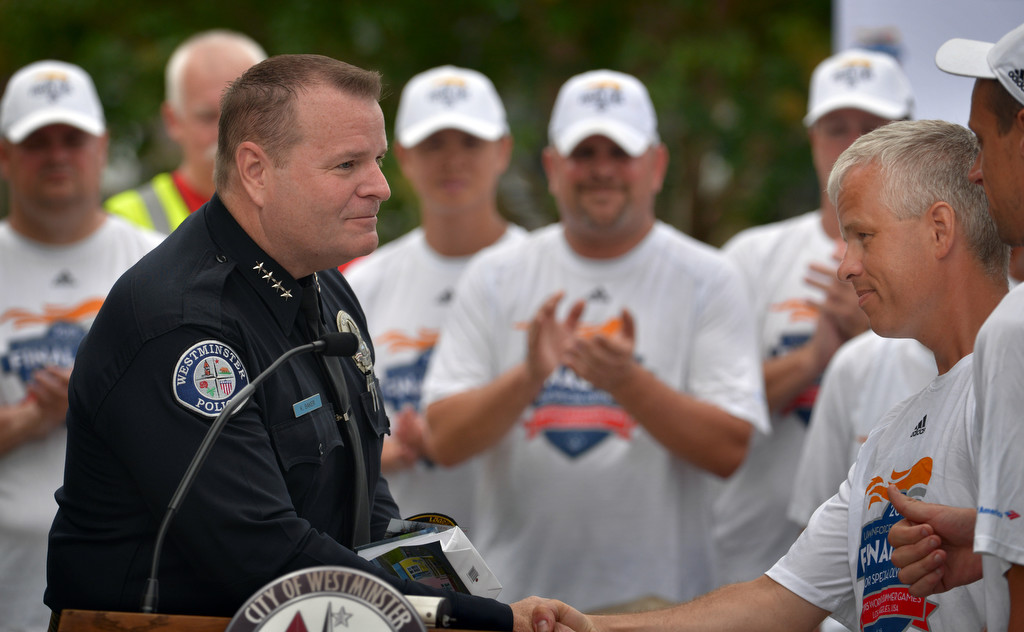 Westminster Police Chief Kevin Baker exchanges gifts with runners from the Enforcement Torch Run Final Leg for Special Olympics during a ceremony at the Westminster PD. Photo by Steven Georges/Behind the Badge OC