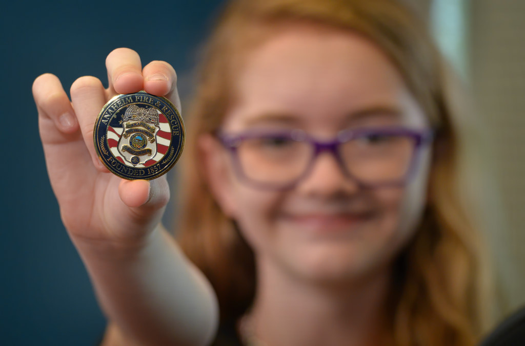 Twelve-year-old Angela Chute shows the Chief’s Coin she received from Anaheim Fire & Rescue Chief Randy Bruegman for her actions when calling 911 during a visit to AF&R headquarters. Photo by Steven Georges/Behind the Badge OC