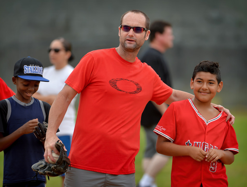 Adam Kennedy, a former MLB player whoÕs career included the Angels and Dodgers, works with Jordan Willard, left, and Roberto Avalos, both 11, during a baseball camp in Fullerton. Photo by Steven Georges/Behind the Badge OC