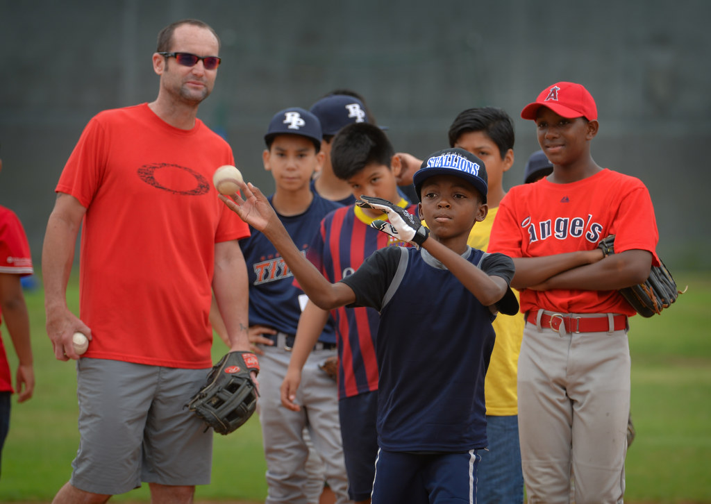 Jordan Willard, 11, tosses a baseball during drills with former MLB player Adam Kennedy, left, during a baseball camp in Fullerton. Photo by Steven Georges/Behind the Badge OC
