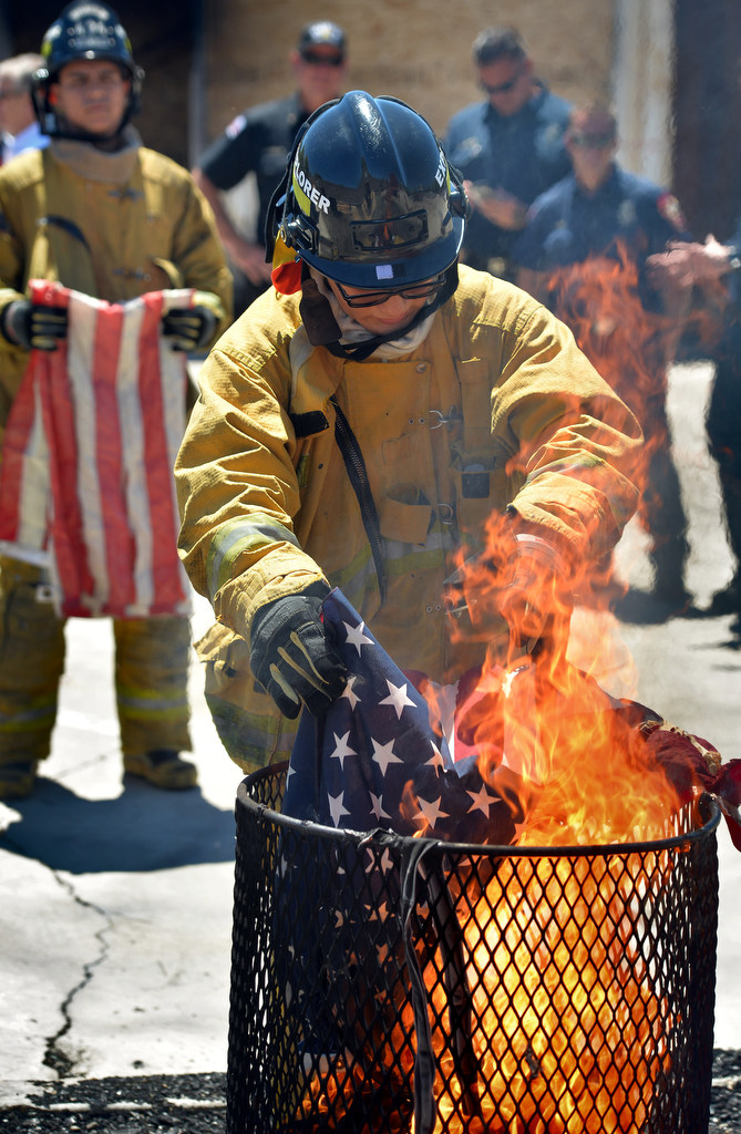 Anaheim Fire & Rescue Explorer Pablo Sanchez retires a flag during a flag burning ceremony at the North Net Fire Training Center in Anaheim. Approximately 430 flags were retired one at a time. Photo by Steven Georges/Behind the Badge OC