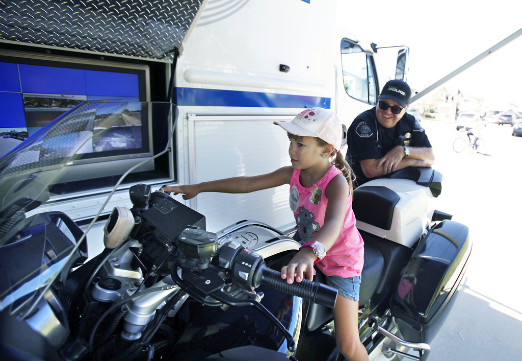Samantha Retrum has the chance to experience the life of a motorcycle office while sitting on Officer Eric Mount's BMW R1200 during the Cypress Community Festival.  Photo by Christine Cotter/Behind the Badge OC