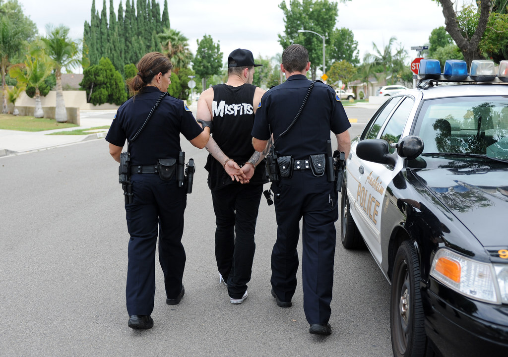 Alisha Halczyn, left, and Daniel Wolfe, of the Anaheim Police Department, arrest a 20-year-old male who was carrying a bag with a loaded gun and drugs in Anaheim Hills, Calif., on Monday, July 20, 2015. Photo by Carlos Delgado  /  Behind the Badge OC