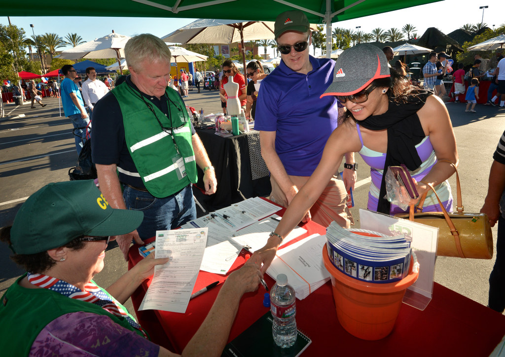 Sharon Cowart, left, and Scott Jackson help Kevin Strong of Tustin and his wife Myra Strong sign up for a CERT (Community Emergency Response Team) class at the City of Tustin’s CERT booth during National Night Out. Photo by Steven Georges/Behind the Badge OC