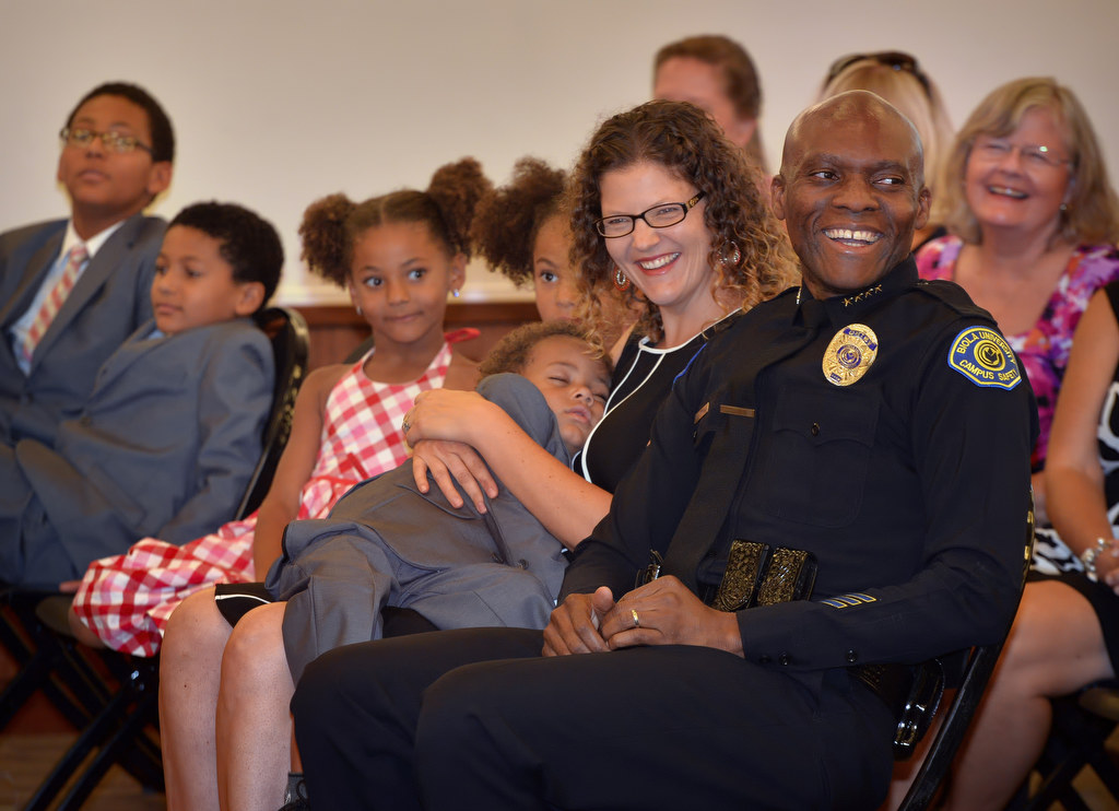 Biola University Chief of Campus Safety and Garden Grove PD Reserve Officer John Ojeisekhoba smiles as he sits with his family during a ceremony honoring him for receiving the Director of the Year Campus Safety award. His family from left is John Jr., 11, Joshua, 10, Nicole, 6, Natalie, 8, James, 3, sleeping in the arms of his wife Heidi. Photo by Steven Georges/Behind the Badge OC
