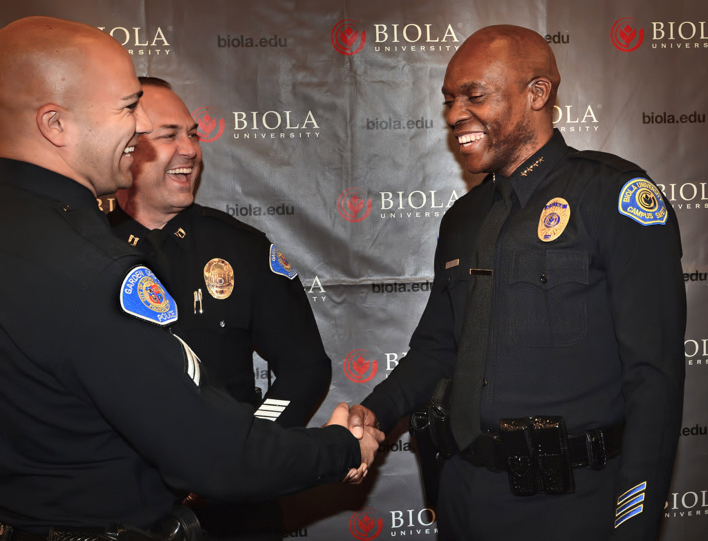 Officer Nick Jensen, left, and Captain Kevin Boddy congratulate Biola University Chief of Campus Safety and Garden Grove PD Reserve Officer John Ojeisekhoba after a ceremony honoring Ojeisekhoba for receiving the Director of the Year Campus Safety award. Photo by Steven Georges/Behind the Badge OC