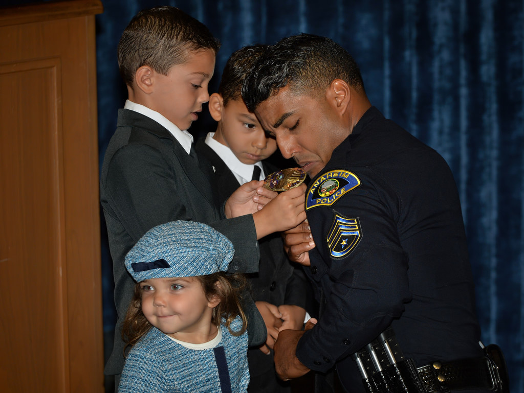 Six-year-old Owen, left, pins an Anaheim PD sergeant badge to his father, Jonathan Bailey, with the help of Jonathan’s other two kids, Logan, 5, and Samantha, 3, during a promotional ceremony. Photo by Steven Georges/Behind the Badge OC
