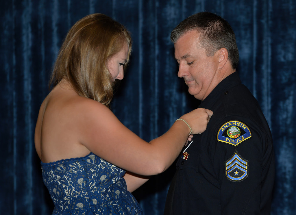 Allie pins an Anaheim PD sergeant badge to her uncle Kelly Phillips during a promotional ceremony at Anaheim PD headquarters. Photo by Steven Georges/Behind the Badge OC