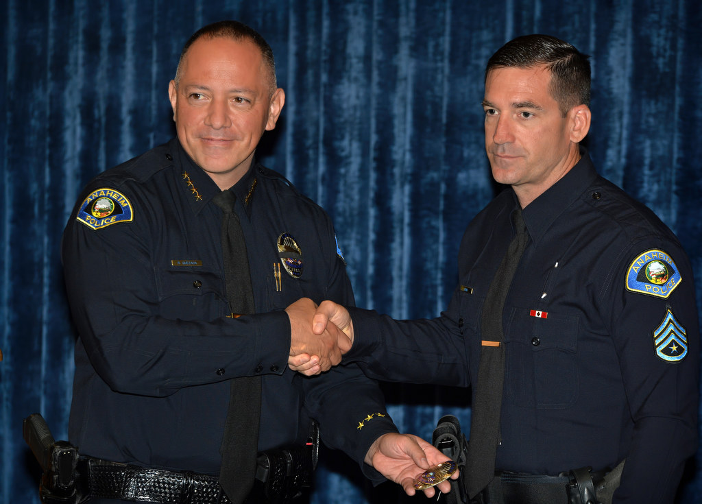 Anaheim Police Chief Raul Quezada, left, hands Stephen Craig his new sergeant badge during a promotional ceremony at Anaheim PD headquarters. Photo by Steven Georges/Behind the Badge OC