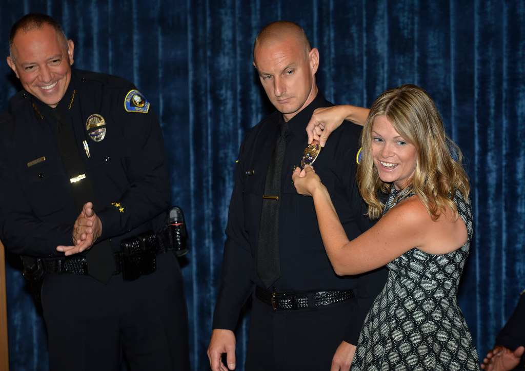 Mark Gell receives his Anaheim officer badge, after moving from Long Beach PD, from his wife Kirsten during a promotional ceremony. Photo by Steven Georges/Behind the Badge OC
