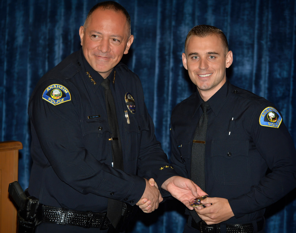Anaheim Police Chief Raul Quezada, left, hands Tyler Kisslan his new Anaheim PD officers badge during a promotional ceremony. Kisslan comes from the Los Angeles Sheriff’s Department. Photo by Steven Georges/Behind the Badge OC