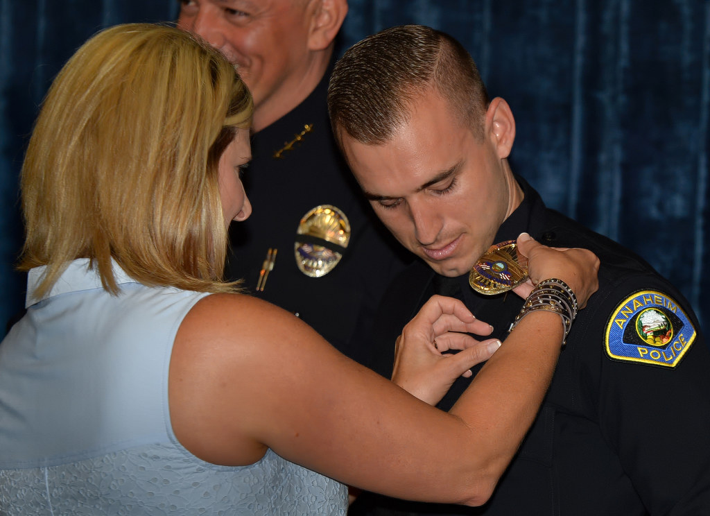 Tyler Kisslan gets his new Anaheim PaD officers badge pinned to him by his xxx during a promotional ceremony. Photo by Steven Georges/Behind the Badge OC