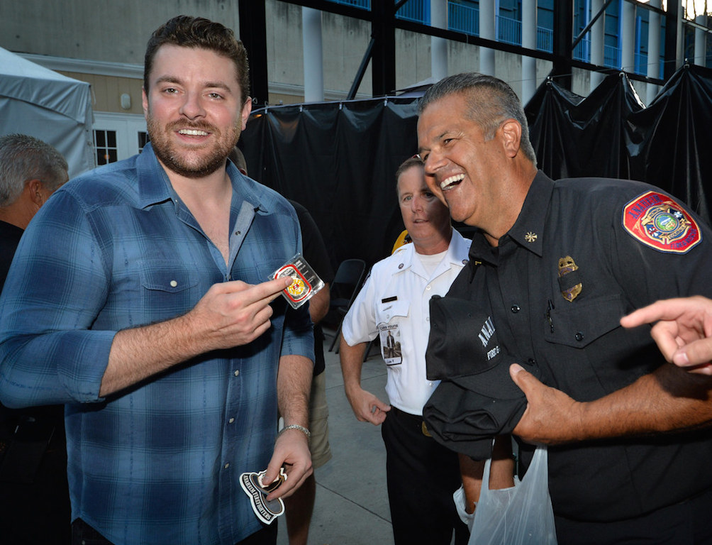 Country singer Chris Young, left, shares a laugh with Anaheim Fire Marshal Jeff Lutz and Anaheim Fire & Rescue Deputy Chief Jeff Alario, right, backstage before his concert at the Pacific Amphitheater as he helps with a program to donate hundreds of smoke alarms to Anaheim and Costa Mesa. Photo by Steven Georges/Behind the Badge OC