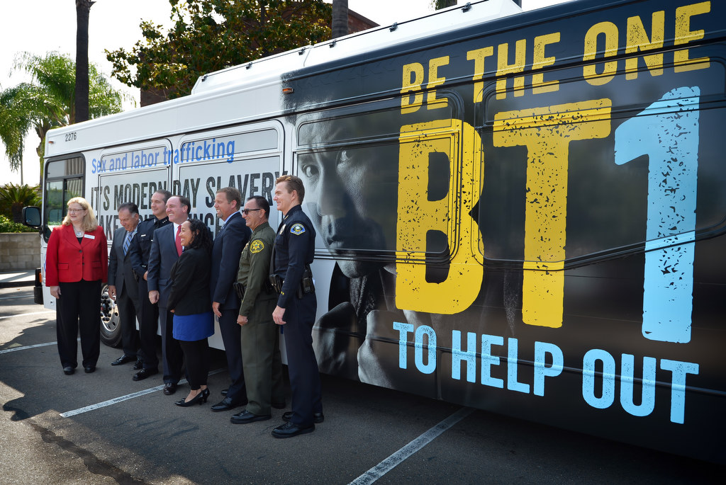 Officials, including Anaheim Deputy Chief Julian Harvey, right, involved in the Orange County Human Trafficking Task Force stand in front of an OCTA buss displaying a new message asking for the public’s help in stoping sex and labor human trafficking. Photo by Steven Georges/Behind the Badge OC