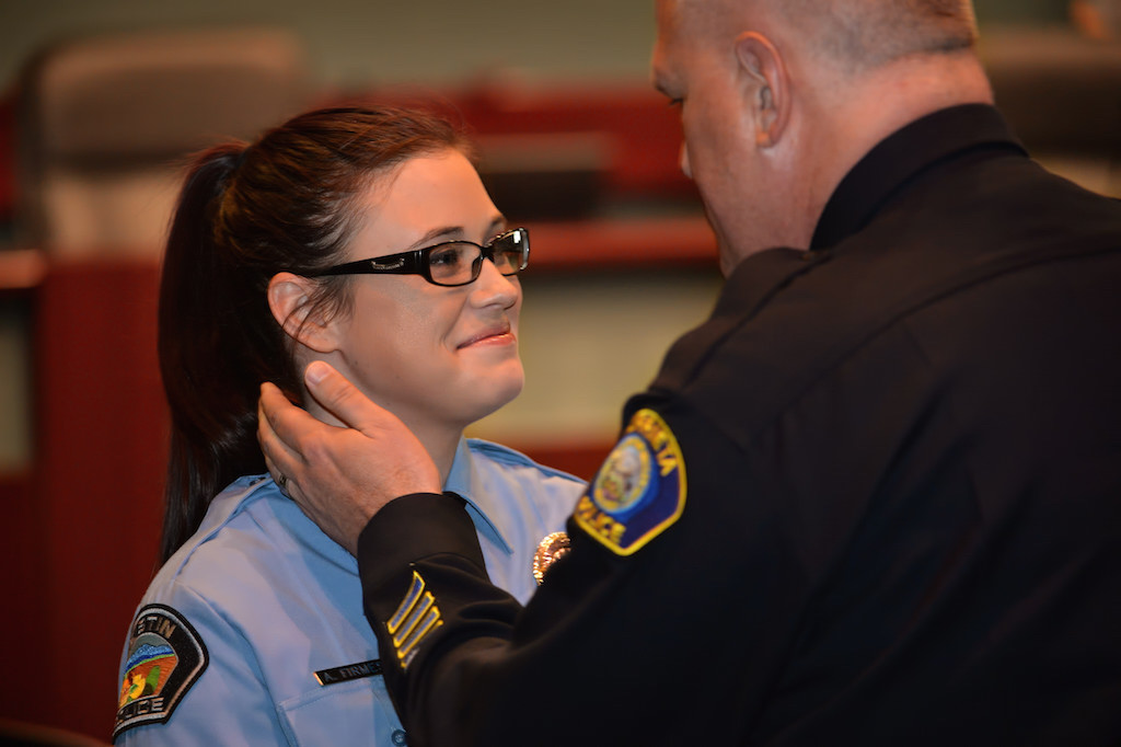 Amber Firmes, a new dispatcher for Tustin PD, is congratulated by her father, Murrieta Police Capt. Rob Firmes, after pinning her new badge on her during a ceremony at the Tustin City Council Chambers.