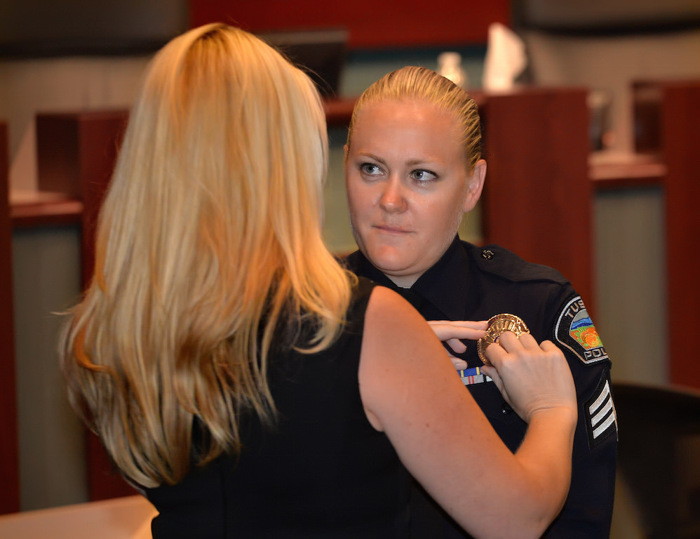 Sara Fetterling receives her new Tustin PD sergeant’s badge from her from her wife Kristin, a Tustin PD dispatcher, during a ceremony at the Tustin City Council Chambers. Photo by Steven Georges/Behind the Badge OC