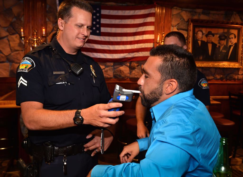 Tustin PD Officer Jeremy Laurich gives a voluntary, info only, alcohol breath test to Brett Simoes of Tustin at Godfather's in Tustin, part of the Know Your Limits program. Photo by Steven Georges/Behind the Badge OC