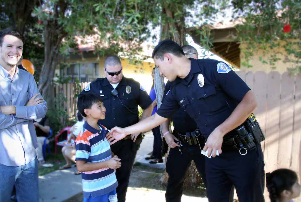 Garden Grove PD Officer David Chang (right) chats with a child as Officer Charlie Danieley looks on. Photo by Van Vu, GGPD
