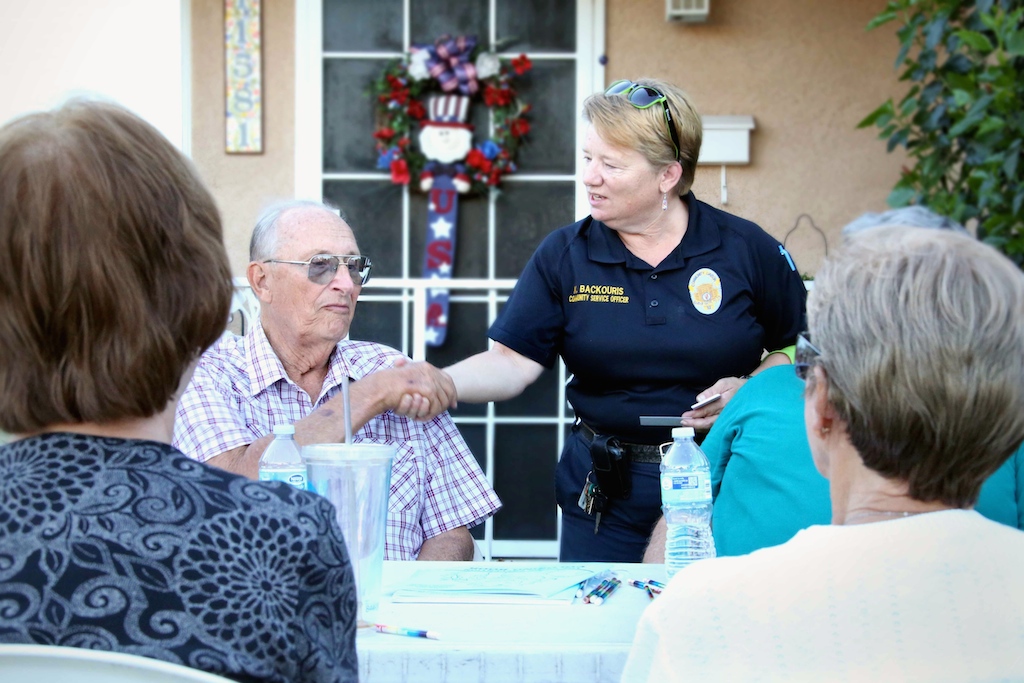 Community Service Officer Kris Backouris of the GGPD greets a resident during National Night Out. Photo by Van Vu, GGPD
