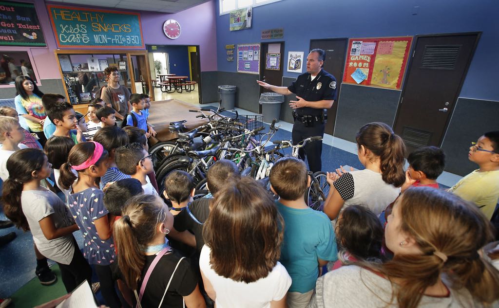 La Habra Chief of Police Jerry Price addresses a group of Boys & Girls Club members after the police department helped deliver a truckload of lost and stolen bicycles to the club. Photo by Christine Cotter/Behind the Badge OC