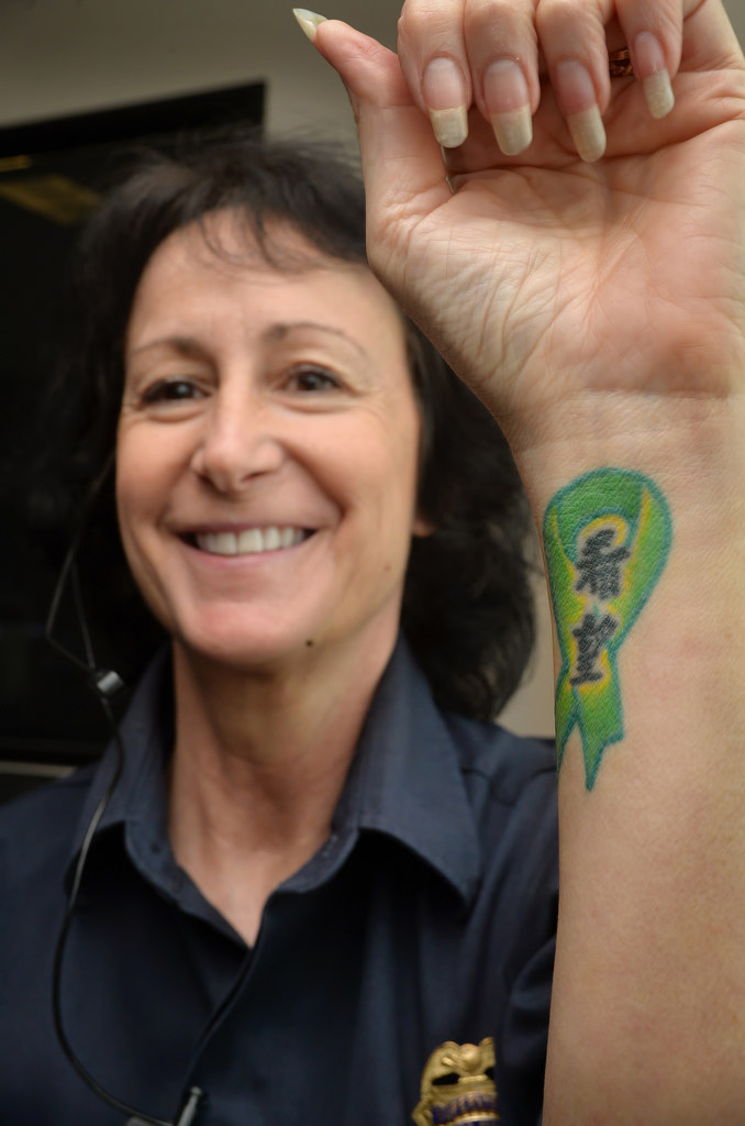Metro Net Dispatch Supervisor Gloria Re shows the tattoo she has for her 21-year-old daughter Autumn who was fifteen when she was diagnosed with Burkitt's lymphoma. The ribbon in Japanese writing says “Hope” Photo by Steven Georges/Behind the Badge OC