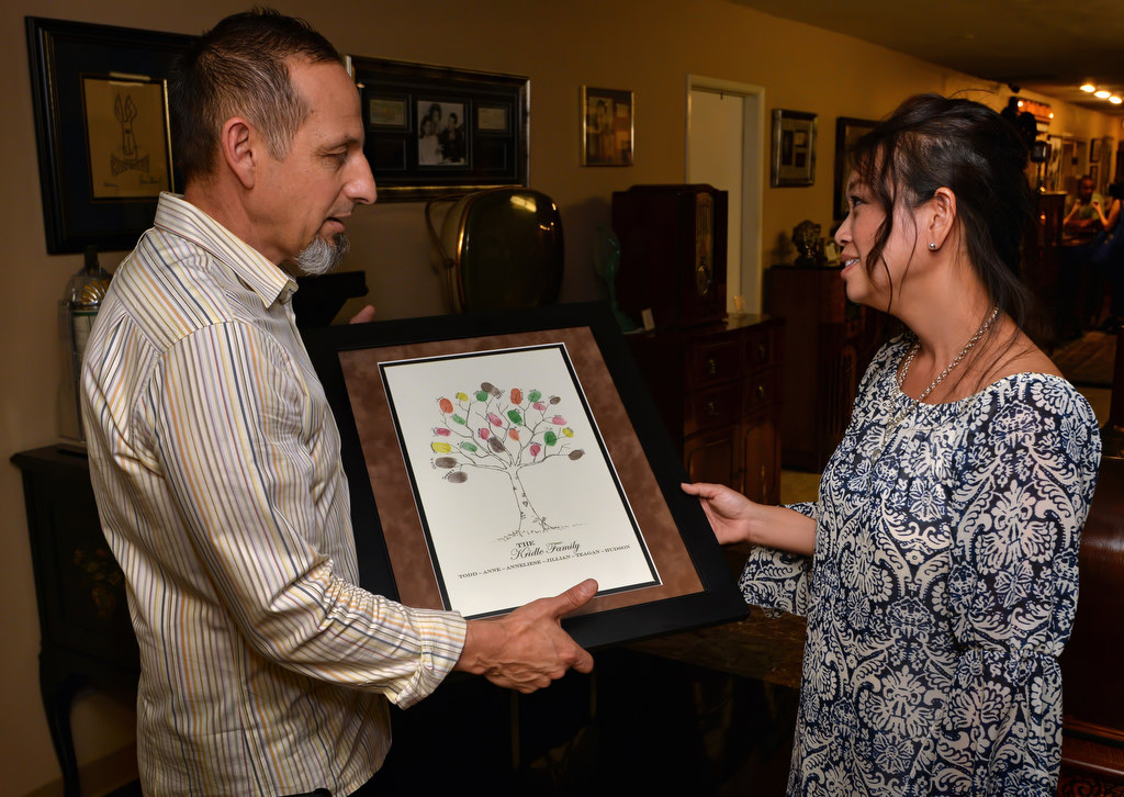 Happy Medina, peer support member and lead coordinator for the Anaheim PD fundraising event, presents Anne Kridle, wife of Anaheim PD Sgt. Todd Kridle who recently passed away from cancer, with a keepsake memento put together by the peer support team that includes the fingerprint and signature of each peer support member to make a tree. A little hear on the trunk of the tree is drawn with T&A inside it for Todd and Anne. Photo by Steven Georges/Behind the Badge OC