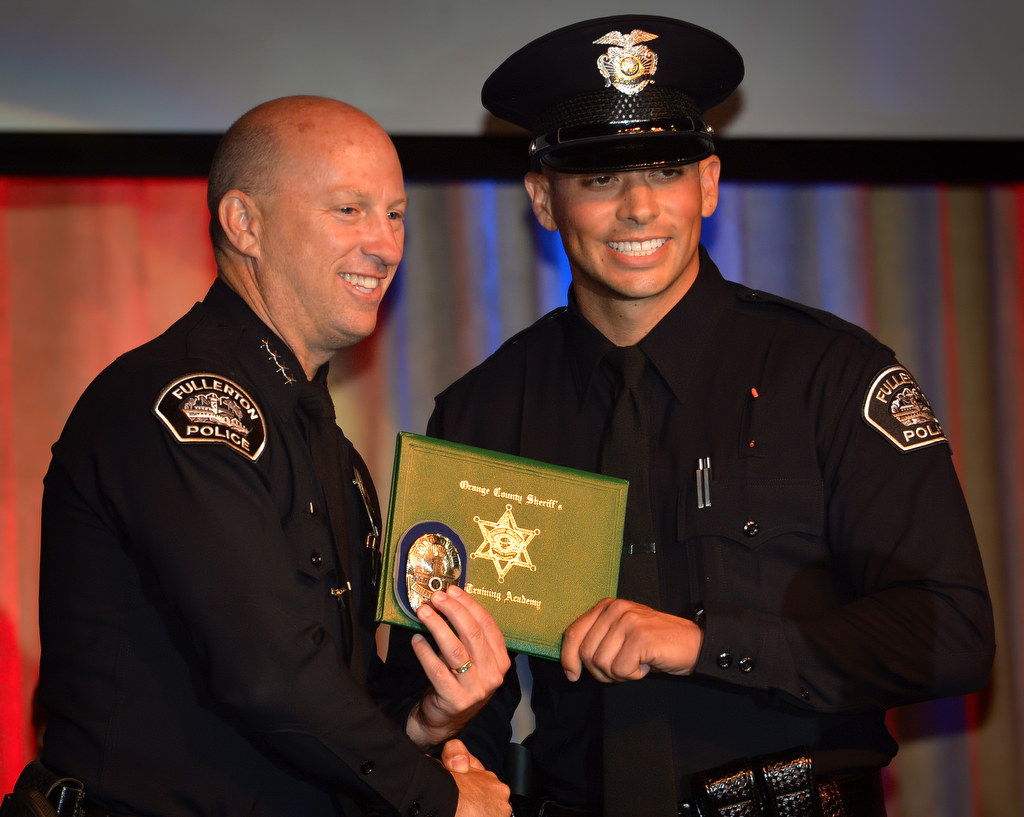 Fullerton Police Chief Dan Hughes presents Officer Marcus Saenz with his new badge during the OCSRTA class of 216’s graduation ceremony. Photo by Steven Georges/Behind the Badge OC
