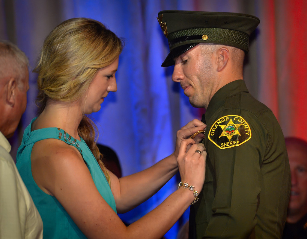 Orange CountyDeputy Andrew Mirth gets his new badge pinned to him by his girlfriend Katie during the OCSRTA class of 216’s graduation ceremony. Photo by Steven Georges/Behind the Badge OC