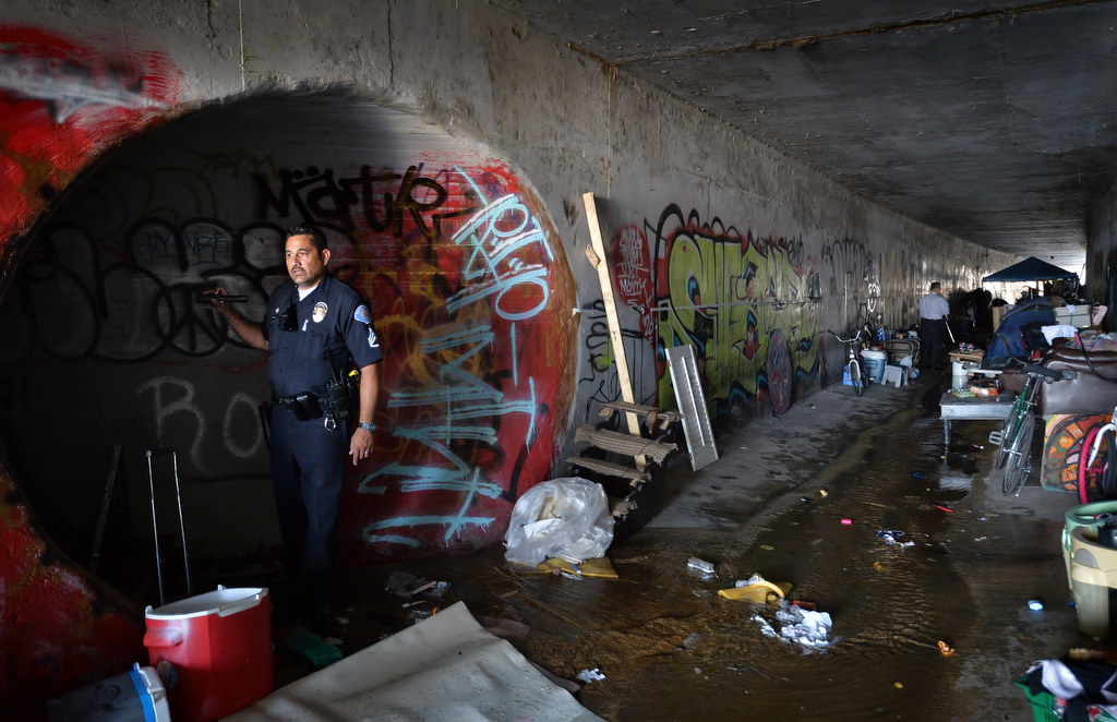Garden Grove PD Sgt. Richard Burillo looks down a side drainage cannel where a bedroom was setup under Knott St. where the homeless were moved out. Photo by Steven Georges/Behind the Badge OC