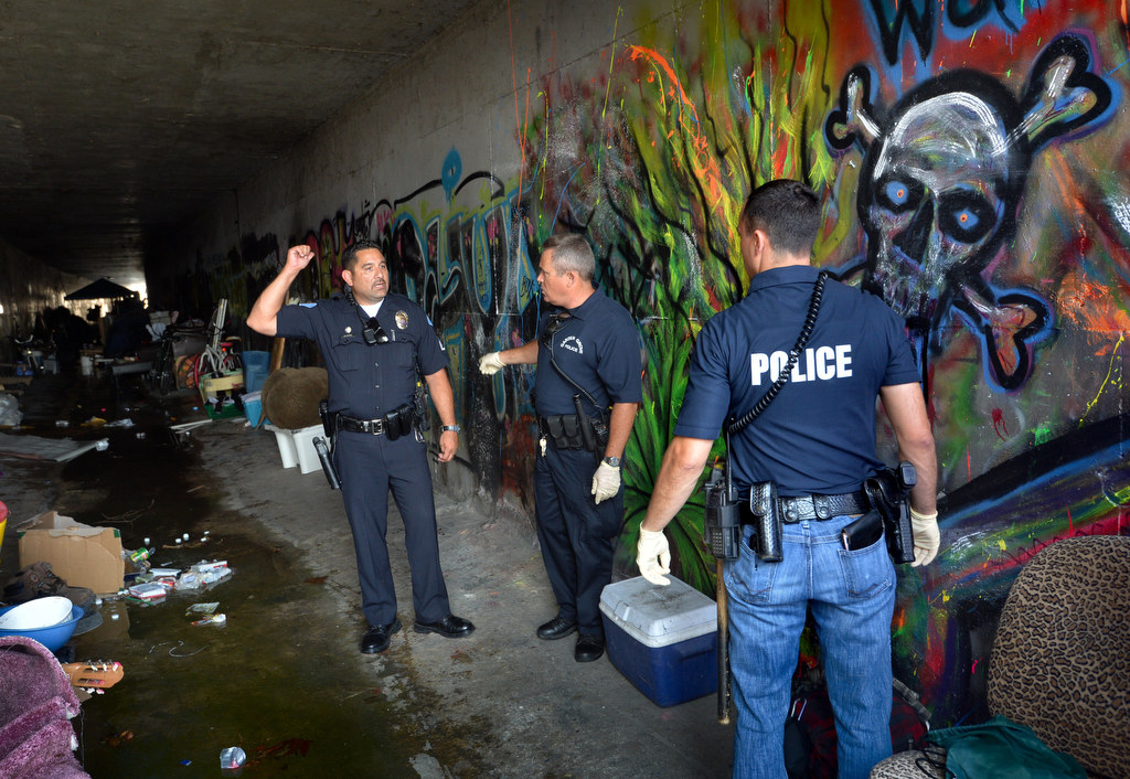 Garden Grove PD officers inspect a flood canal under Knott Street after the people living there were removed. Police believe the homeless there were not responsible for the graffiti. Photo by Steven Georges/Behind the Badge OC