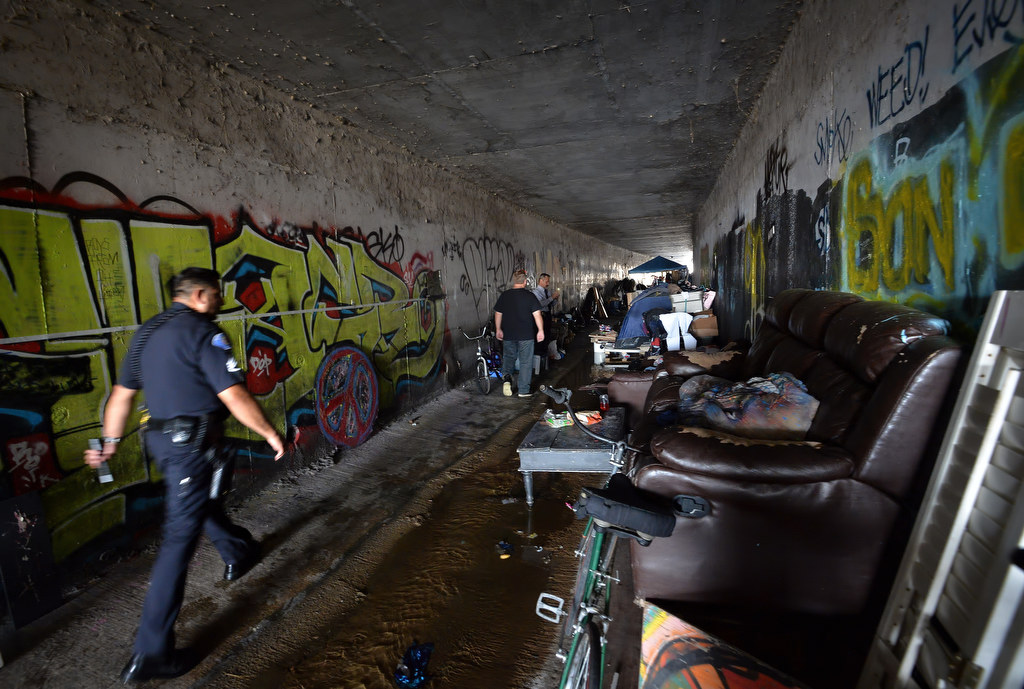 Garden Grove PD officers inspect a flood canal under Knott St. after the people living there were removed. Police believe the homeless living there were not responsible for the graffiti. Photo by Steven Georges/Behind the Badge OC