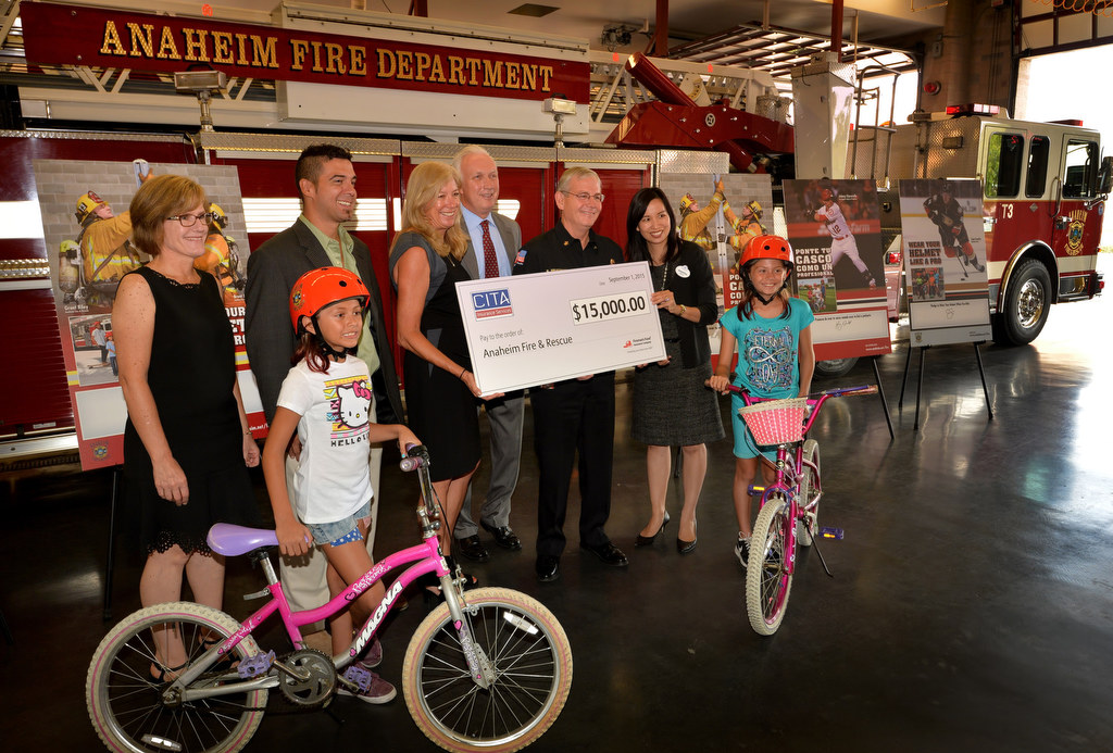 Sally Archbold and John Neiminski of Fireman’s Fund Insurance Company/Allianz and John Jasinski of CITA Insurance Services present Anaheim Fire & Rescue Chief Randy Bruegman with a check for $15,000 for Anaheim’s Wear Your Helmet Like A Pro campaign during a press conference at Anaheim fire station 3. Photo by Steven Georges/Behind the Badge OC