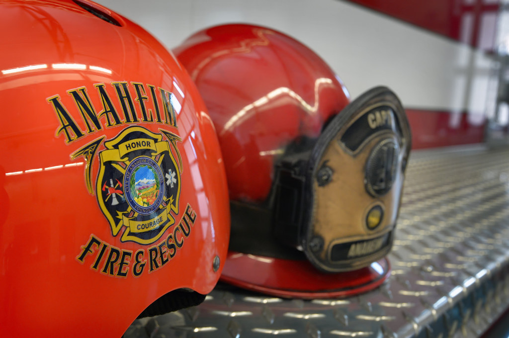 Anaheim’s Wear Your Helmet Like A Pro campaign bicycle helmet next to an Anaheim Fire & Rescue helmet. Photo by Steven Georges/Behind the Badge OC
