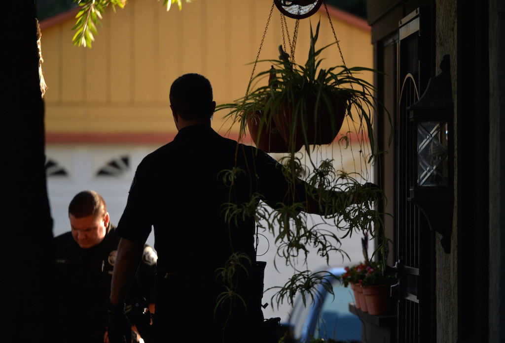 A Tustin PD officer knocks on a door looking for a probationer as other officers stand by. No one was home. Photo by Steven Georges/Behind the Badge OC