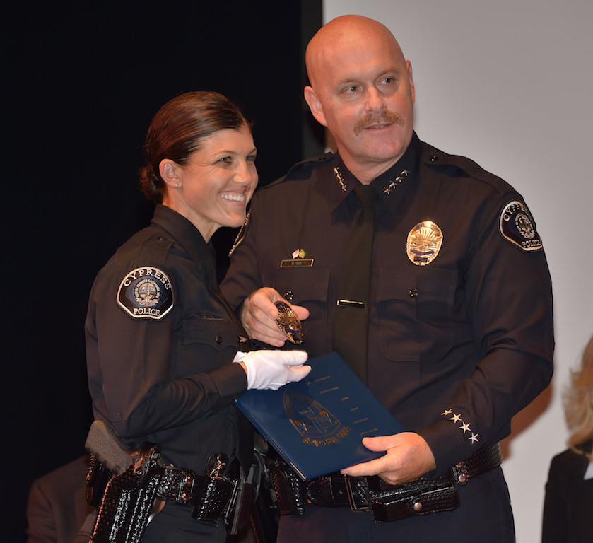 Cypress PD’s Melissa Grove receives her badge from Cypress Police Chief Rod Cox during the Golden West College Basic Police Academy, Class 150, graduation ceremony. Grove was later honored with the Director’s Award. Photo by Steven Georges/Behind the Badge OC