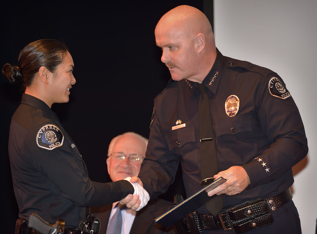 Cypress PD’s Claire Tran gets a congratulatory hand shake from Cypress Police Chief Rod Cox before receiving her badge during the Golden West College Basic Police Academy, Class 150, graduation ceremony. Photo by Steven Georges/Behind the Badge OC