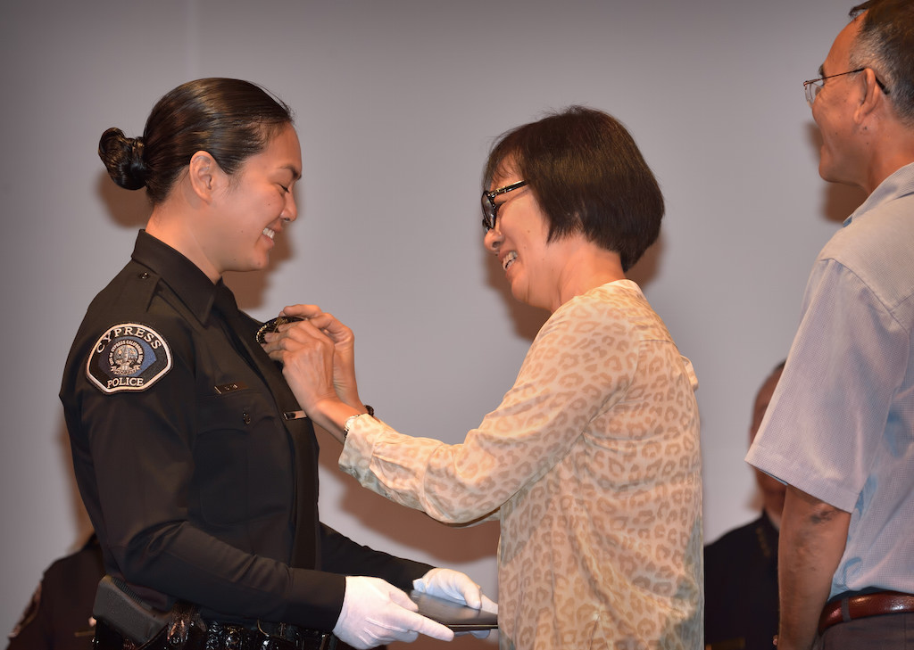 Cypress PD’s Melissa Grove gets her badge pinned to her by her family during the Golden West College Basic Police Academy, Class 150, graduation ceremony. Photo by Steven Georges/Behind the Badge OC
